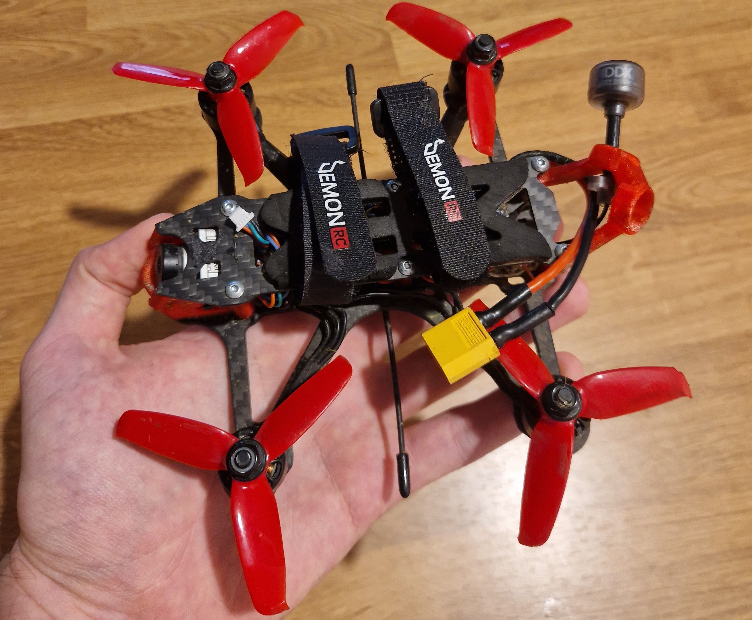 Black and red quadcopter held in hand