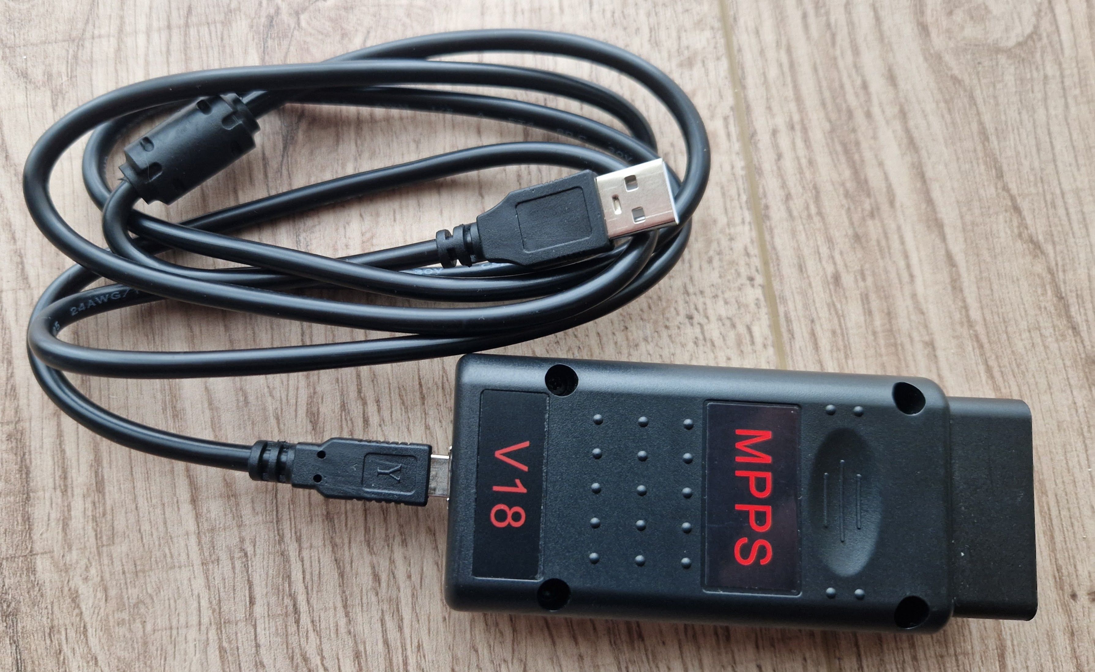 MPPS V18 automobile ECU programming tool placed on ground next to USB cable